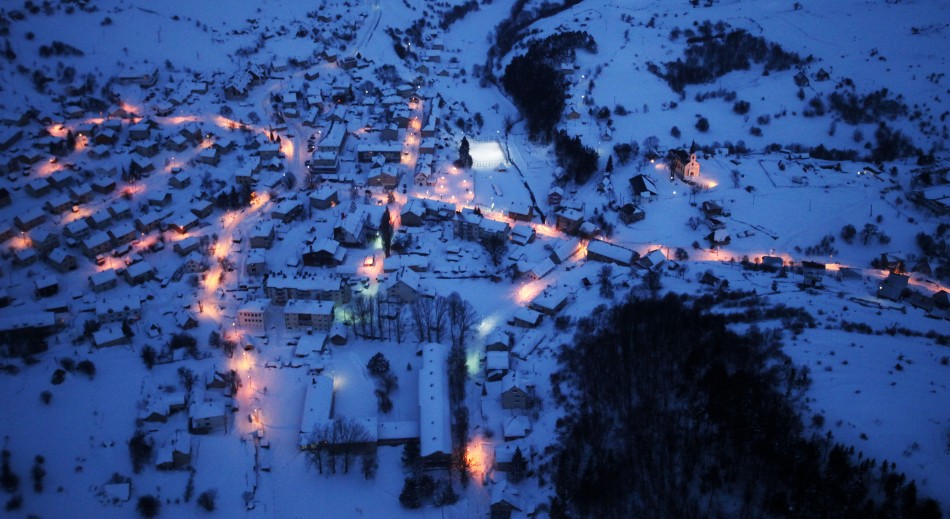 An aerial view of the small eastern city of Kalinovik covered by snow during winter at night