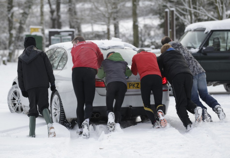 Passing runners help push a stranded car stuck in the ice and snow in Newtown Linford, Leicstershire