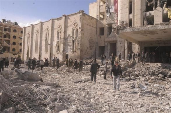 Syrian workers inspect the site of an explosion