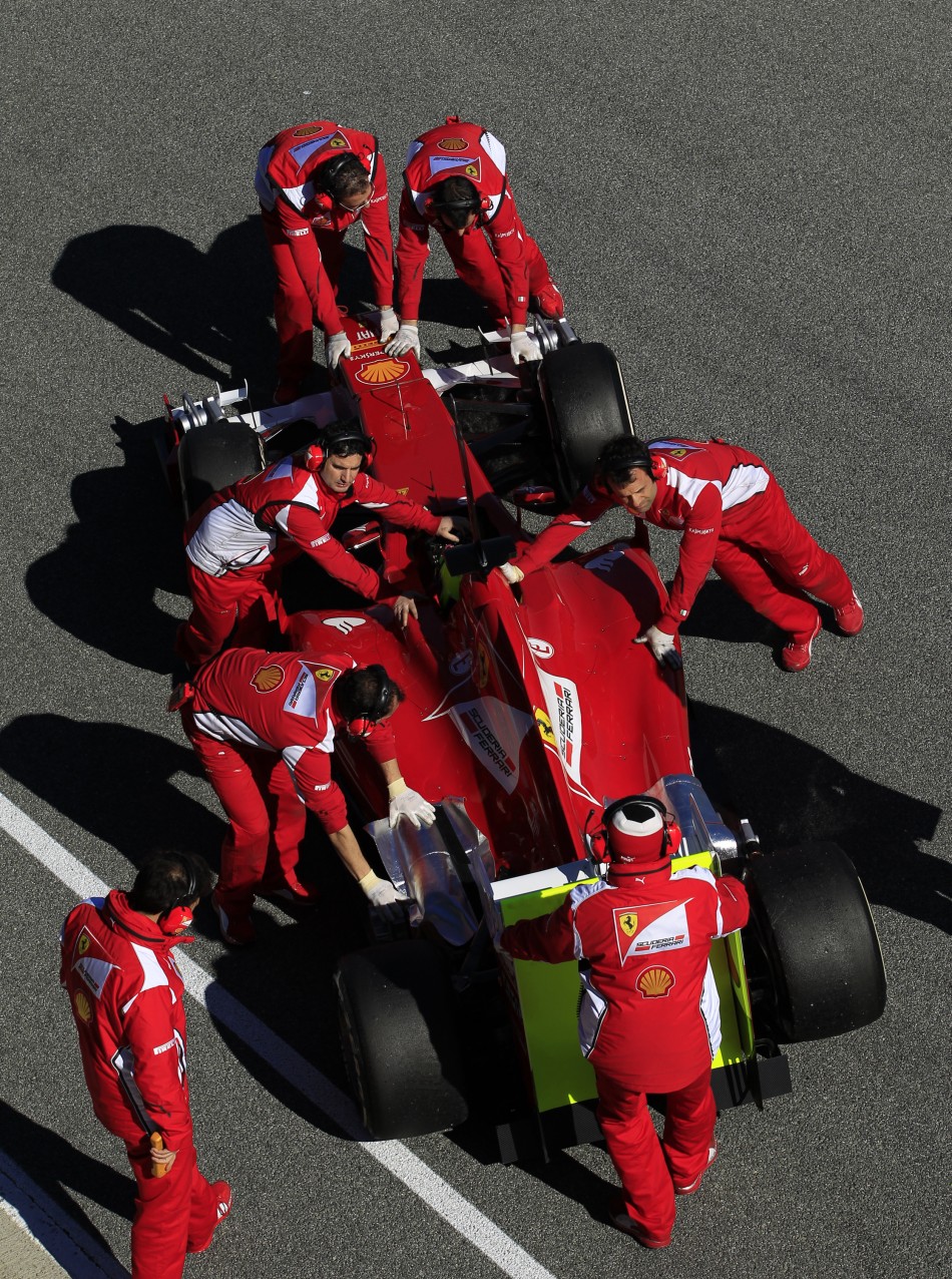 Ferrari F1 driver Massa of Brazil sits inside his 663 as team members push his car into the garage in Jerez