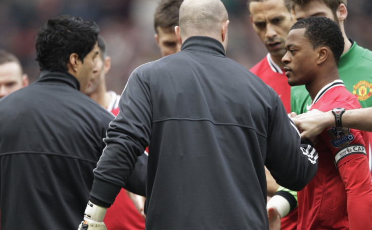 Manchester United's Evra reacts after Liverpool's Suarez ignored his handshake before their English Premier League soccer match in Manchester