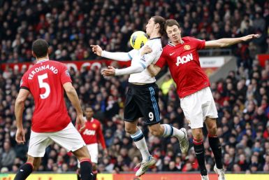 Manchester United's Evans challenges Liverpool's Carroll during their English Premier League soccer match in Manchester