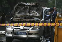 Police and forensic officials examine damaged car at Israeli Embassy after explosion in New Delhi