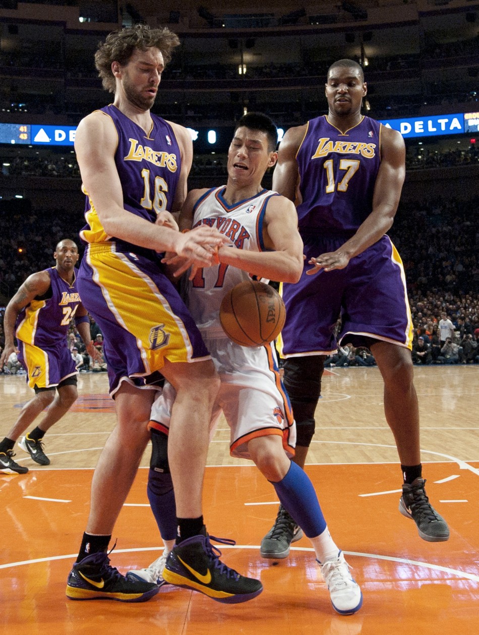 Los Angeles Lakers Pau Gasol and center Andrew Bynum force New York Knicks Jeremy Lin to lose ball in NBA game in New York
