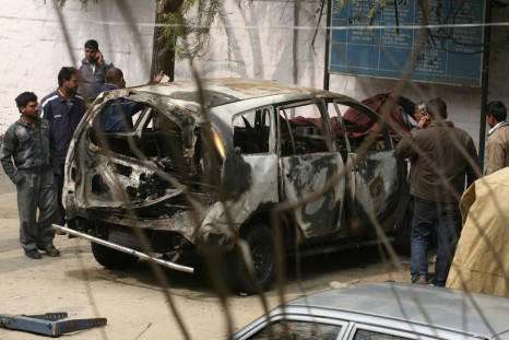 Police cover the damaged Israeli embassy car in New Delhi