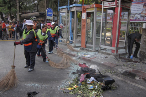 Cleaners at  the site where a man was injured when a bomb he was carrying exploded, in central Bangkok