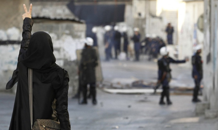A protester shows a victory sign to riot police during clashes in Bahrain