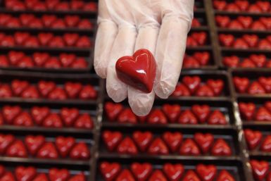 A worker displays a heart-shaped praline