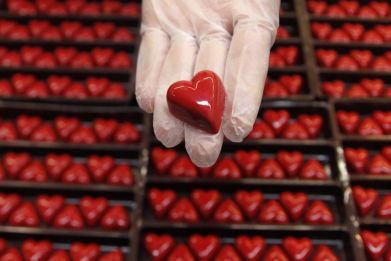 A worker displays a heart-shaped praline