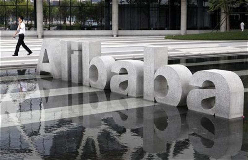 A man walks past a logo of Alibaba (China) Technology Co. Ltd at its headquarters on the outskirts of Hangzhou