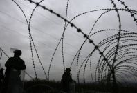 Kosovo Force (KFOR) soldiers from Germany stand guard near barbed wire along a road in the village of Jagnjenica, near Zubin Potok