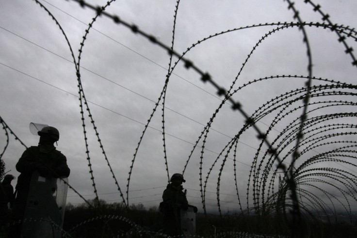 Kosovo Force (KFOR) soldiers from Germany stand guard near barbed wire along a road in the village of Jagnjenica, near Zubin Potok