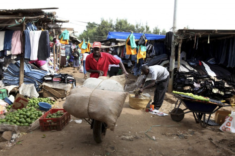 Man pushes handcart through market in Kibera, Nairobi