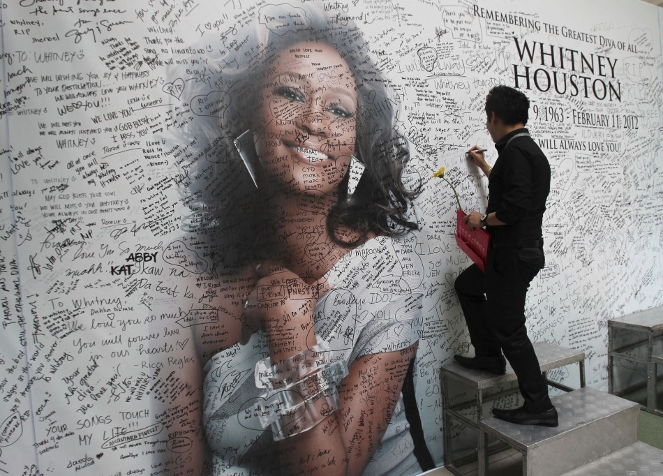 Filipino fan writes a message on a tribute wall for late American singer-actress Whitney Houston in Manila