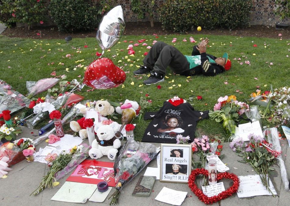 Thirteen-year-old Collier lays behind a makeshift memorial to singer Whitney Houston at a corner of the Beverly Hilton Hotel