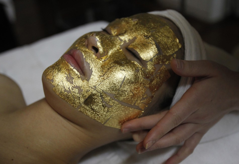 An employee pastes gold leaves onto a client039s face at the Viet My beauty salon in Hanoi