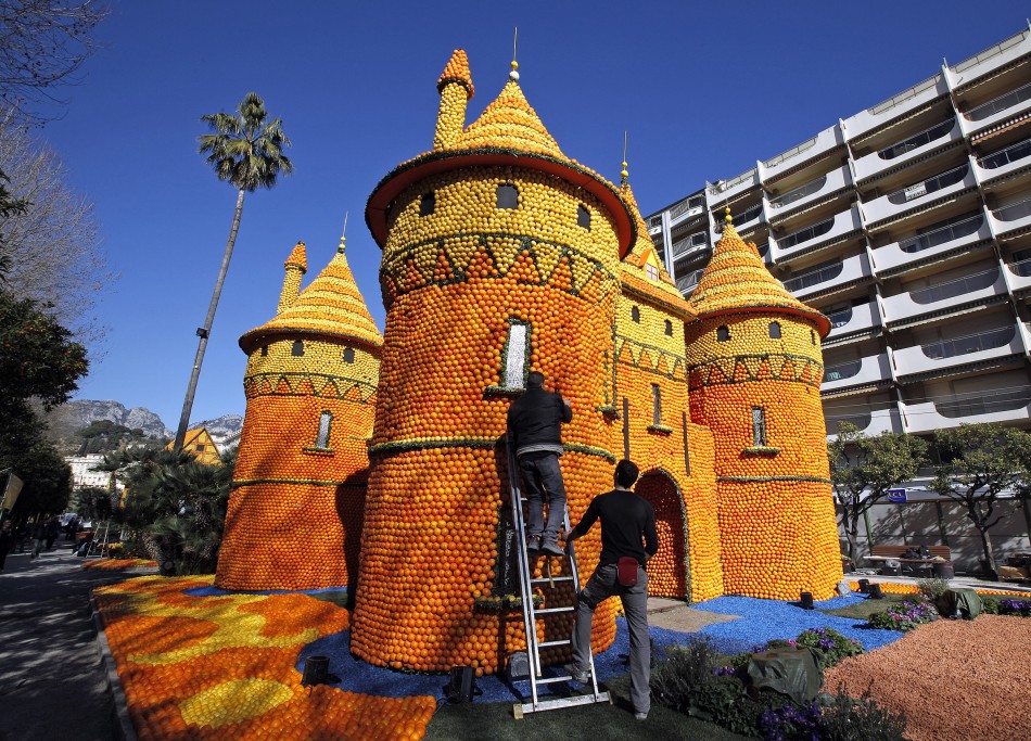 Workers put final touches to a castle made from lemons and oranges during the lemon festival in Menton