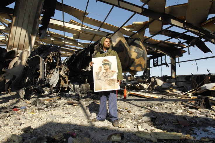 A Libyan holds a poster of Libya's leader Muammar Gaddafi