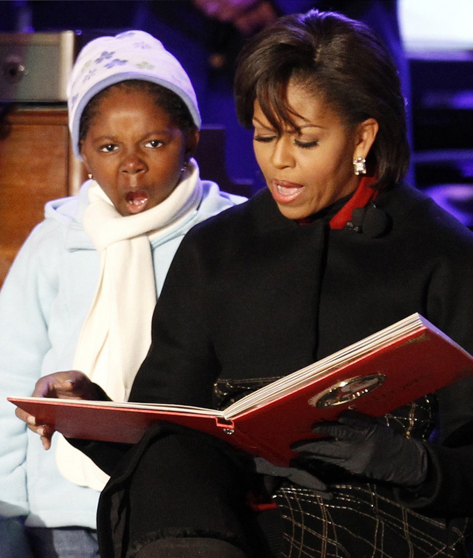 U.S. first lady Michelle Obama reads a Christmas book to children on stage during the National Christmas Tree Lighting ceremony in Washington