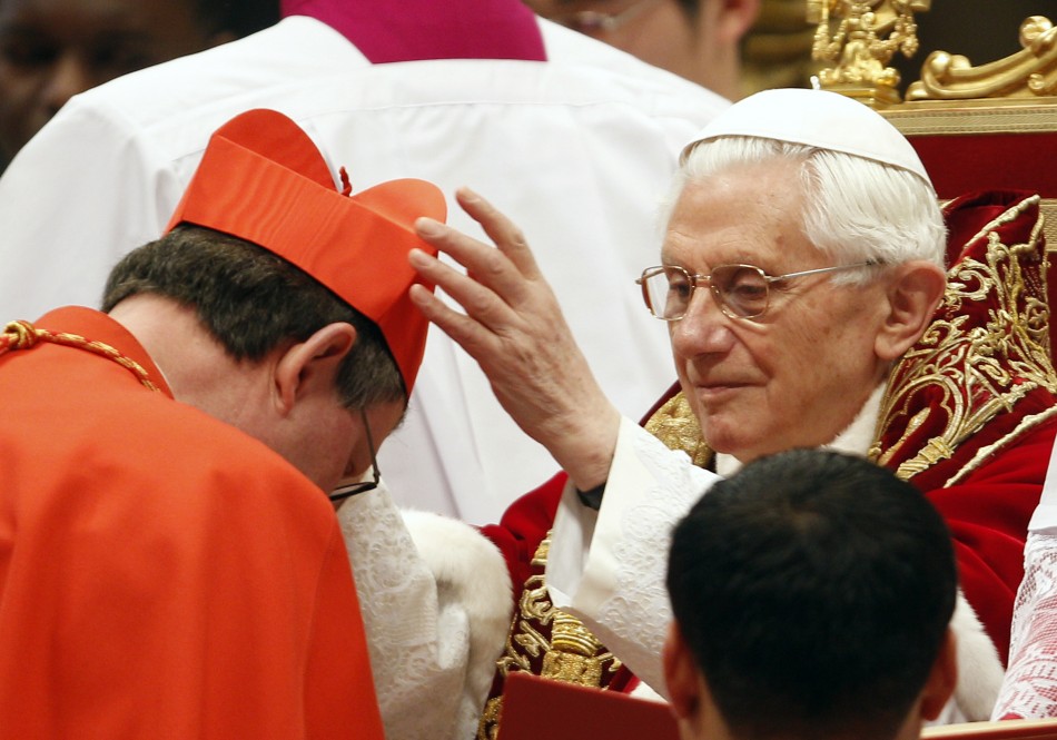 Pope Benedict XVI places a red biretta, a four-cornered hat, on the head of new Cardinal Rainer Maria Woelki of Germany