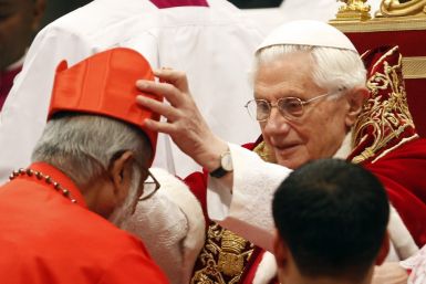 Pope Benedict XVI places a red biretta, a four-cornered hat, on the head of new Cardinal George Alencherry of India