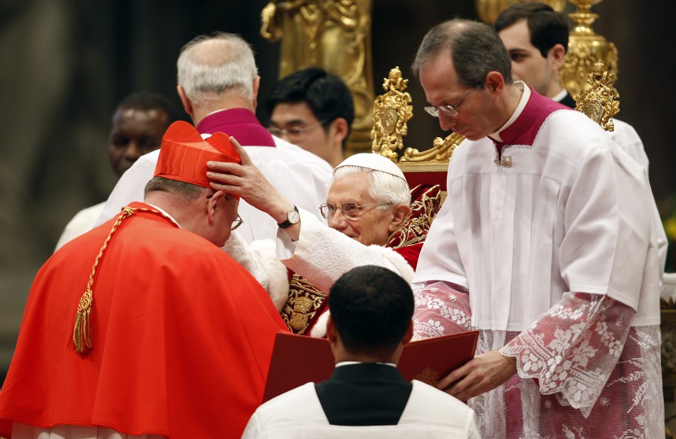 Pope Benedict XVI places a red biretta, a four-cornered hat, on the head of new Cardinal Timothy Dolan of the U.S.