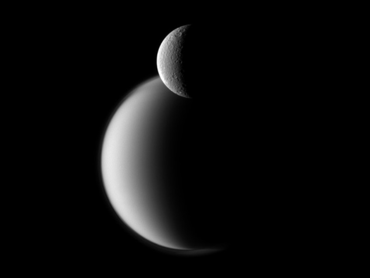 Craters appear well defined on icy Rhea in front of the hazy orb of larger Titan in this view of the two Saturn moons. NASA's Cassini spacecraft snapped the photo on Dec. 10, 2011