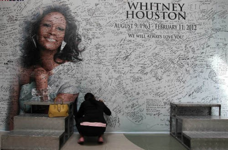 A Filipino fan writes a message on a tribute wall for the late American singer-actress Whitney Houston in Manila
