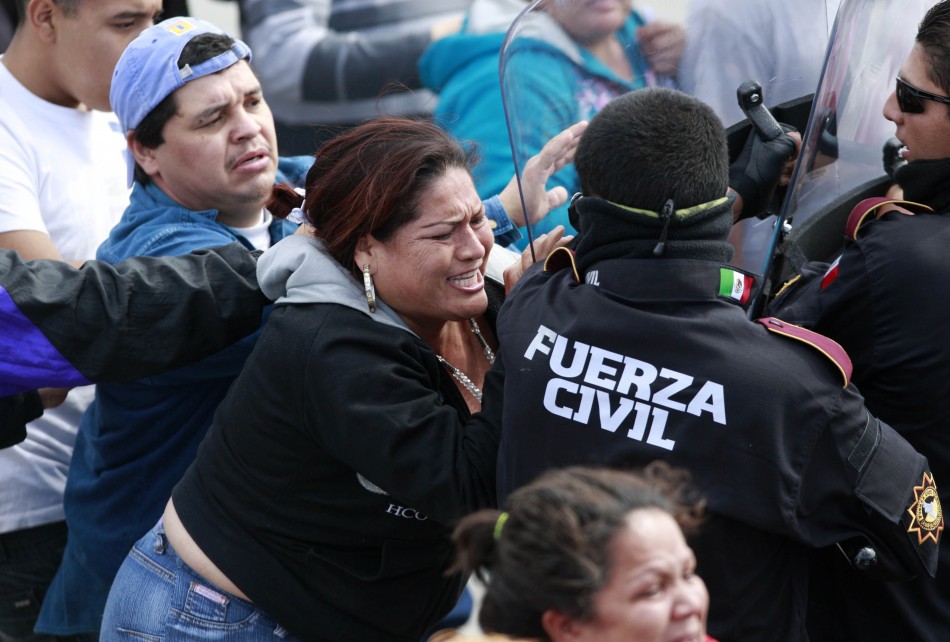 Angry relatives of inmates confront police officers outside the state prison in Apodaca