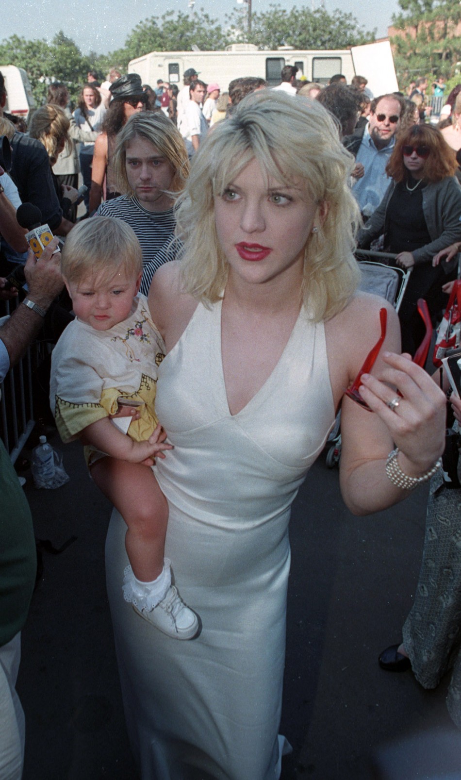 Kurt Cobain L, behind baby as he arrives with wife Courtney Love