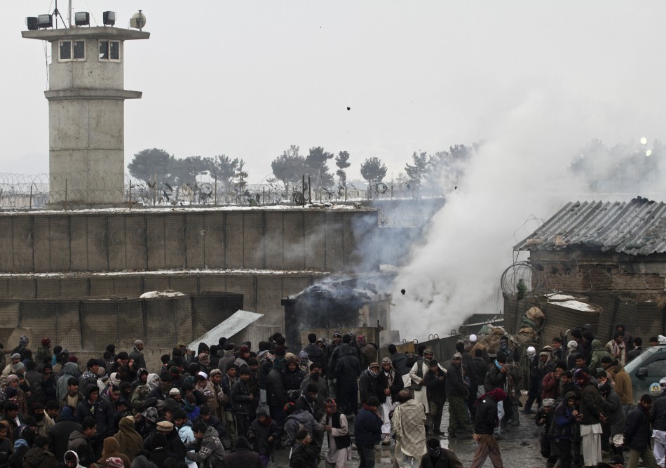 Afghan men gather as some of them throw rocks towards the U.S. military base during a protest in Bagram