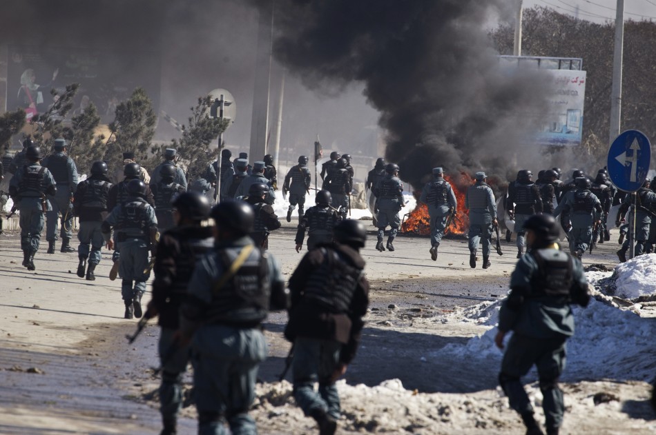 Afghan policemen march towards protesters during a protest near a U.S. military base in Kabul