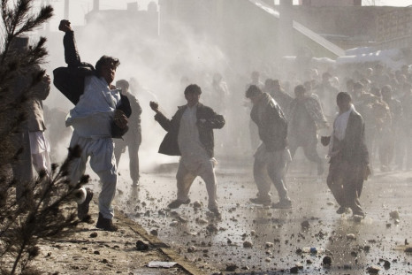 Afghan protesters throw rocks towards a water canon near a U.S. military base in Kabul