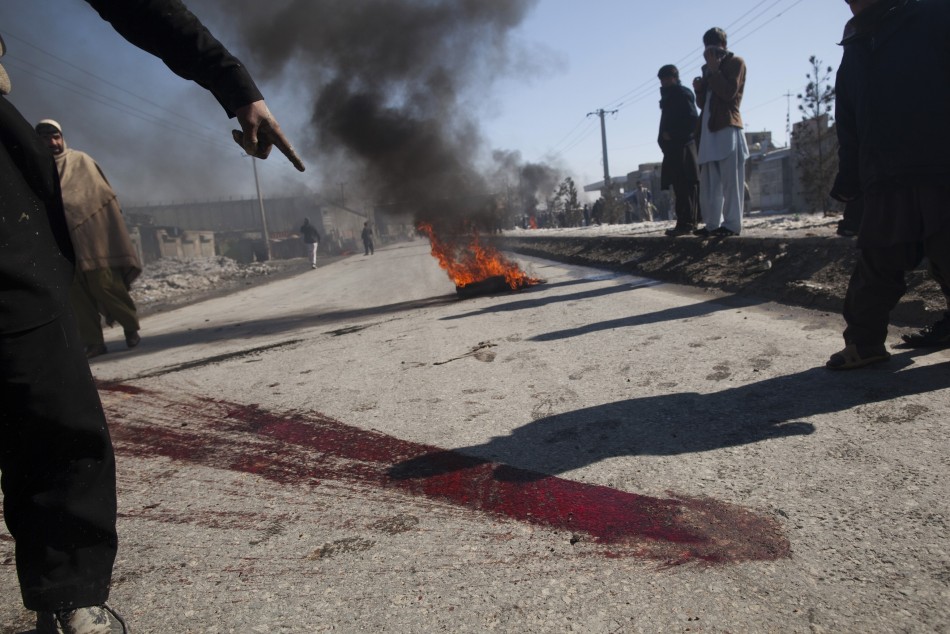 An Afghan man points to blood on a street during a protest near a U.S. military base in Kabul