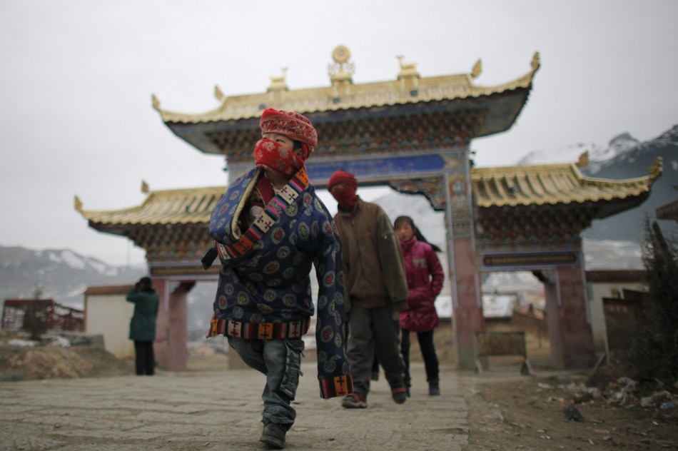 An ethnic Tibetan family arrive at a temple during Tibetan New Year celebrations in Langmusixiang