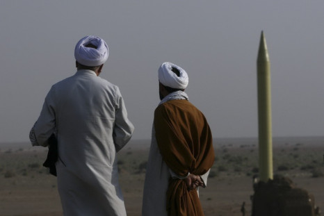 Iranian clerics stand near surface-to surface-missile ready to be launched during war game near city of Qom