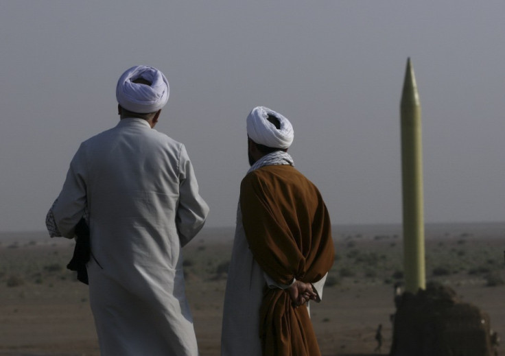 Iranian clerics stand near surface-to surface-missile ready to be launched during war game near city of Qom