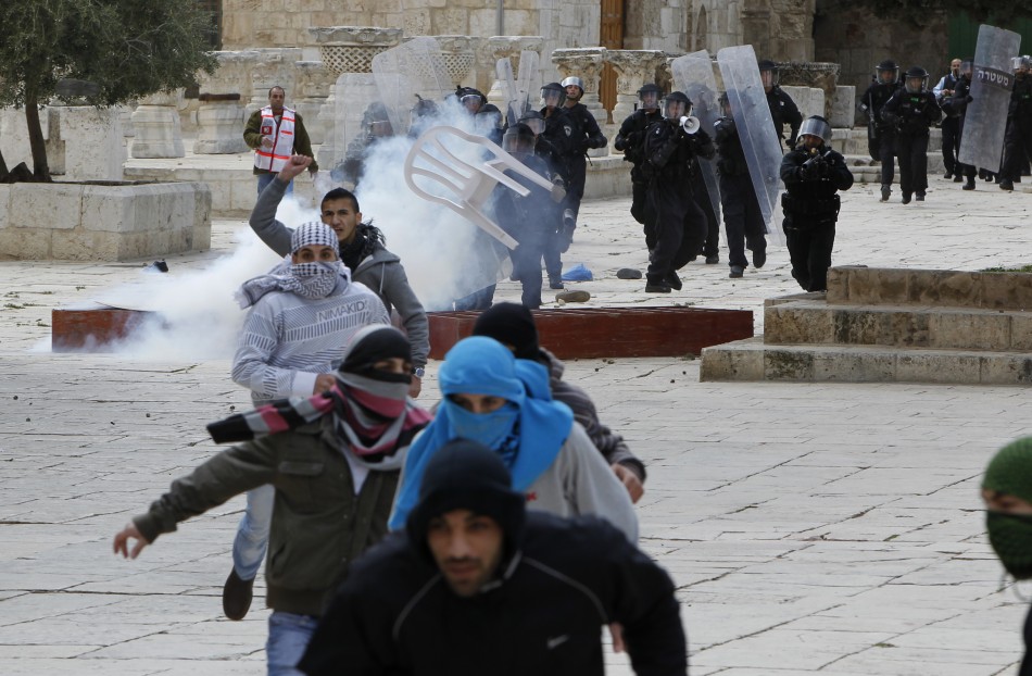 Palestinian protesters run away from Israeli policemen