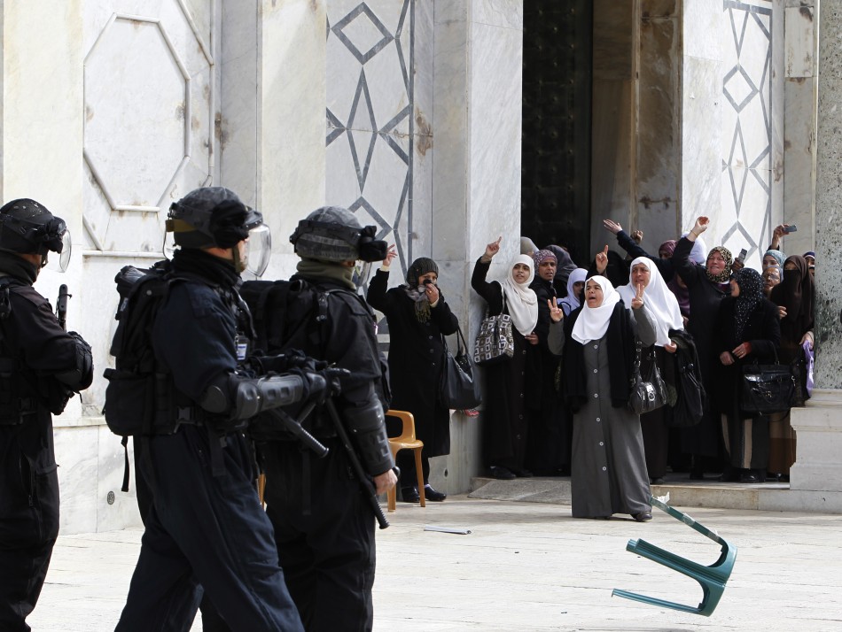Palestinian women gesture as they shout at Israeli policemen