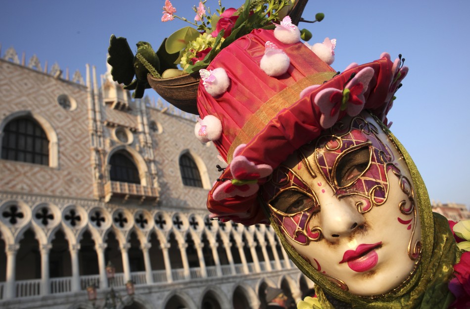 A masked reveller poses in Saint Marks Square