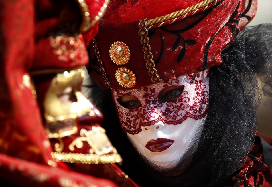 Masked revellers pose in Saint Marks Square