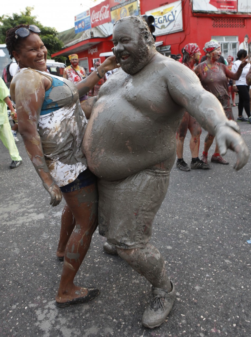 People covered in mud dance during Jouvert celebrations