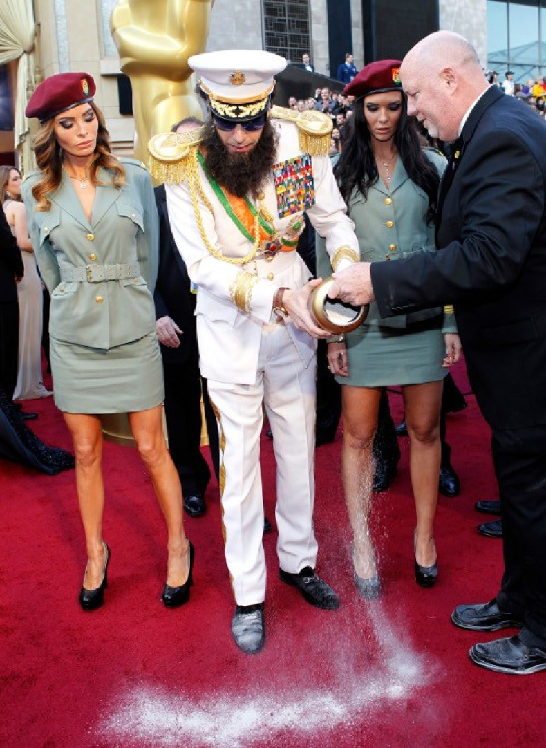 Cohen arrives in character from his upcoming film &quot;The Dictator&quot; while dumping the contents of an urn with a picture depicting   North Korea's late leader Kim Jong-il on it at the 84th Academy Awards in Hollywood