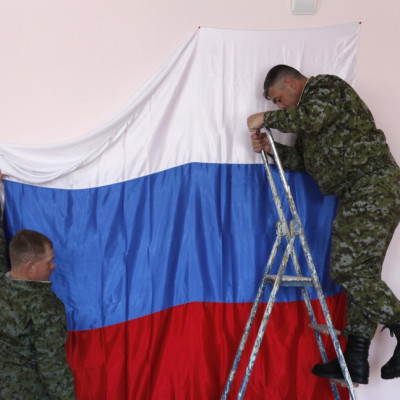Russian soldiers hang their national flag at a polling station