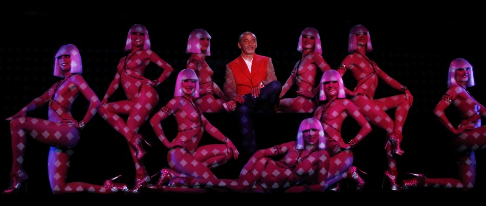 Designer Christian Louboutin poses with dancers during the press presentation of the new revue named Feu at the Crazy Horse in Paris