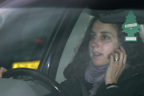 A woman uses her mobile phone whilst driving in London