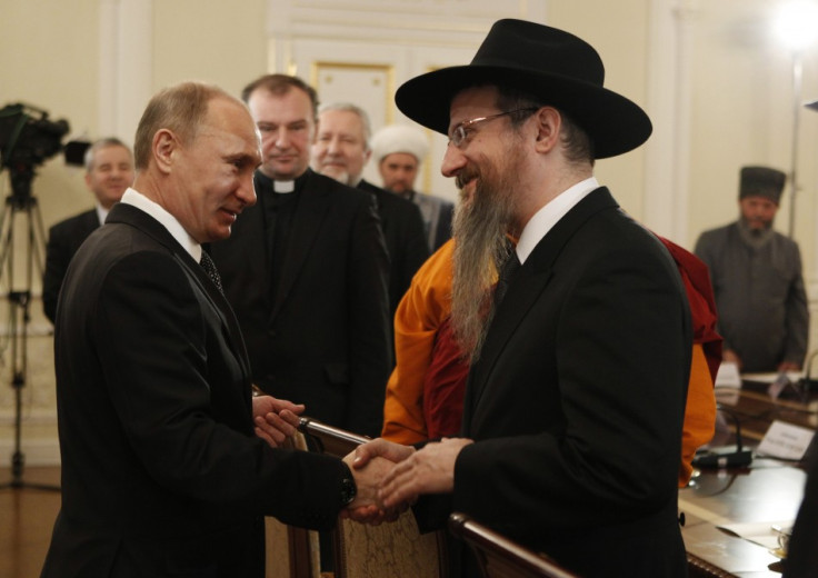 Prime Minister Vladimir Putin shakes hands with Chief Rabbi Berel Lazar, as he met with religious leaders in Moscow