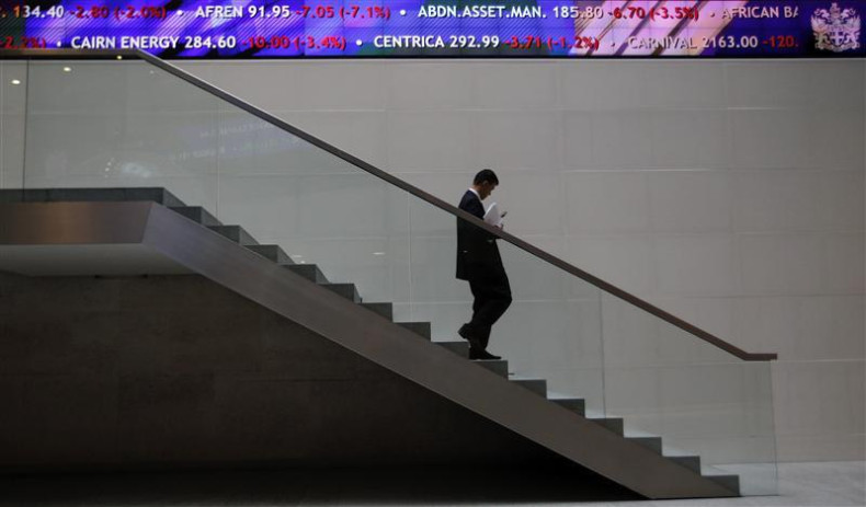 A man walks down steps under a share price ticker at the London Stock Exchange in the City of London