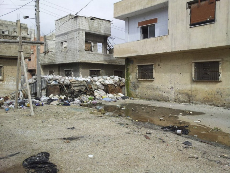 Damaged houses are seen in Karm Al Zaytoon, a neighbourhood of Homs