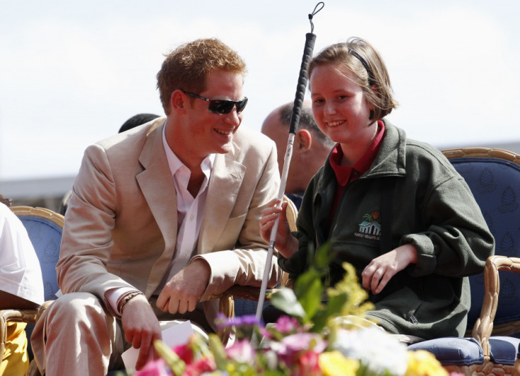 Britain's Prince Harry talks to Anna Albury as he attends a youth rally and cultural show at the National Stadium in Nassau